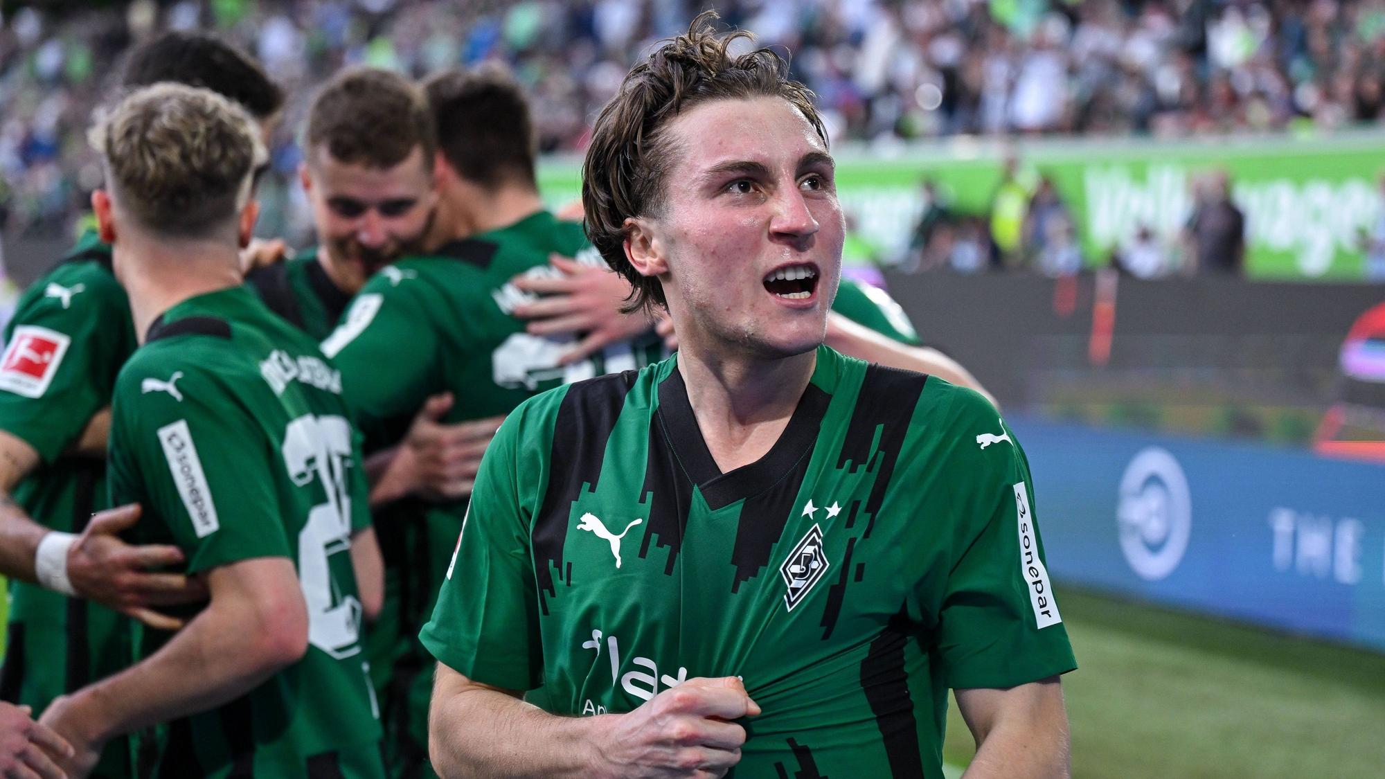 Rocco Reitz greift sich ins Trikot und schaut jubelnd zu den Fans hoch.