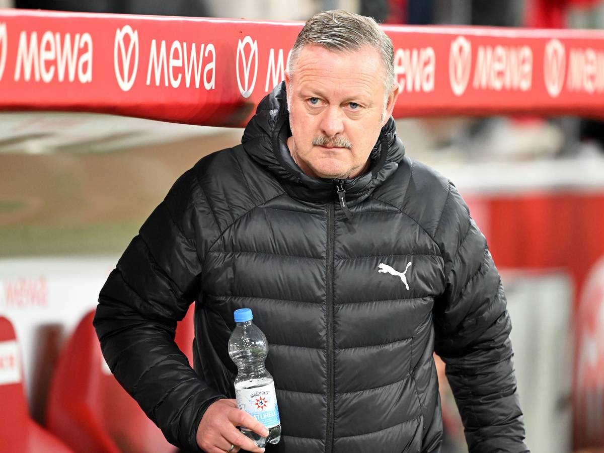 Roland Virkus beim Spiel in Mainz auf der Trainerbank mit einer Wasserflasche in der Hand.
