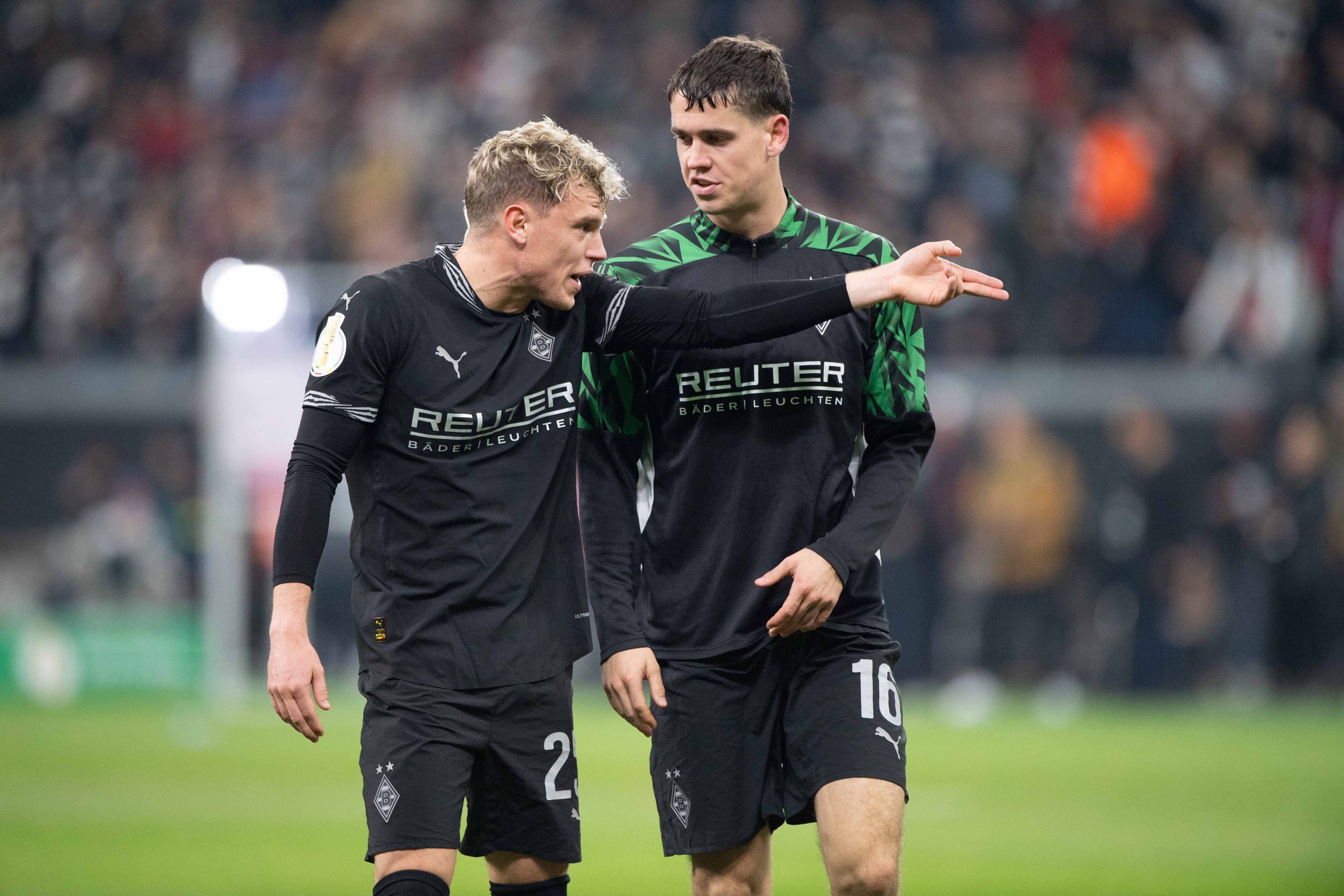 Borussia Mönchengladbachs Robin Hack spricht mit Teamkollege Philipp Sander nach dem Pokal-Spiel bei Eintracht Frankfurt.