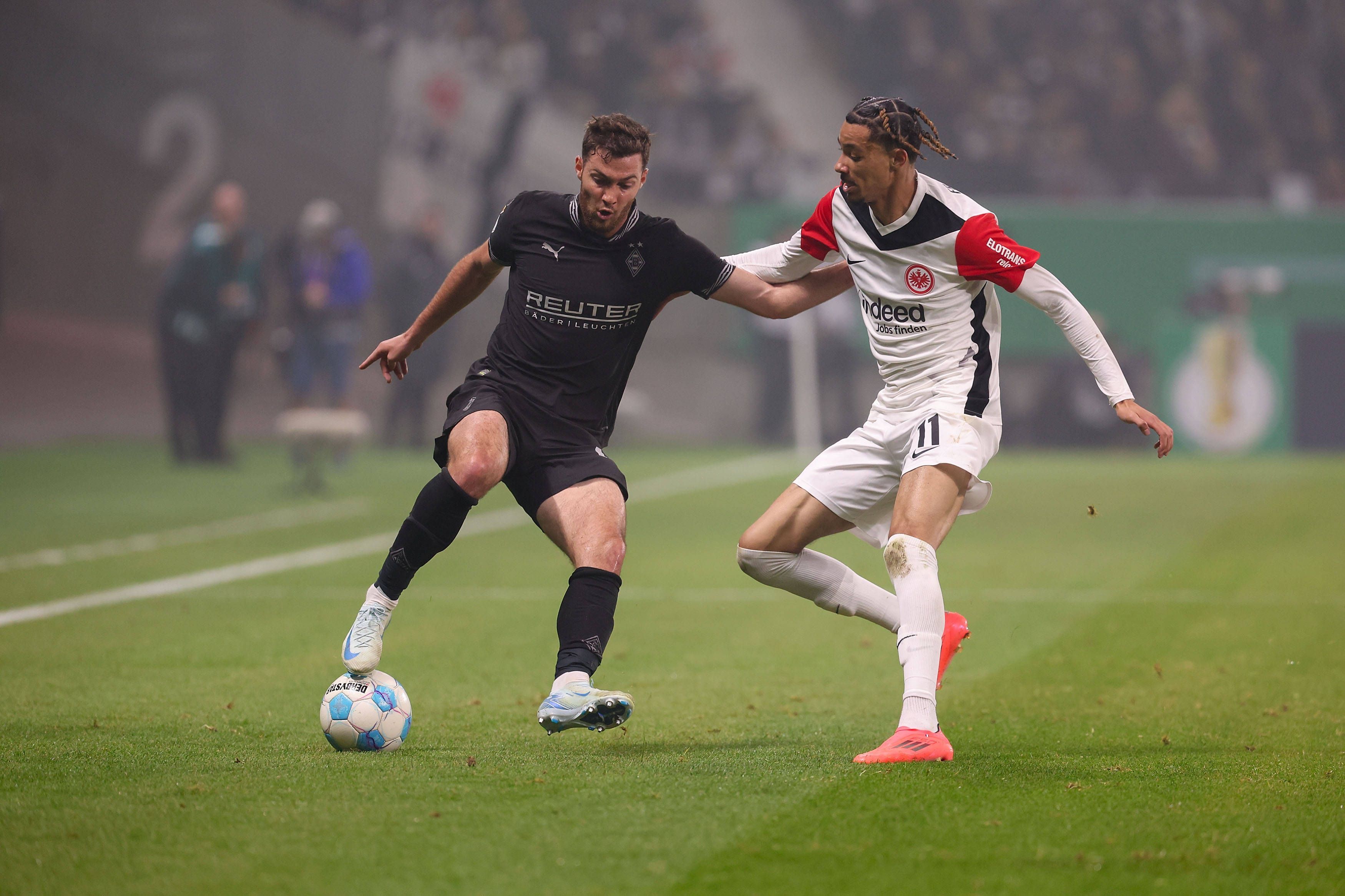 Borussia Mönchengladbachs Joe Scally und Eintracht Frankfurts Hugo Ekitiké kämpfen um den Ball.