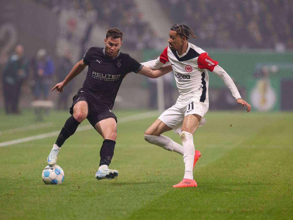 Borussia Mönchengladbachs Joe Scally und Eintracht Frankfurts Hugo Ekitiké kämpfen um den Ball.