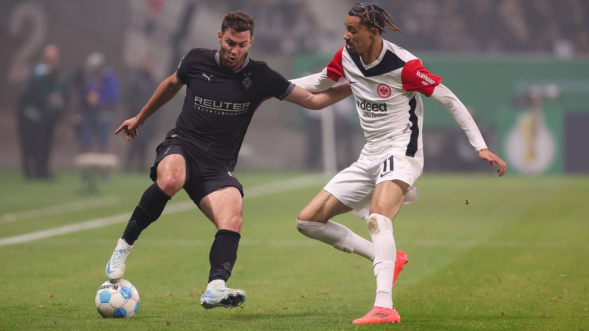 Borussia Mönchengladbachs Joe Scally und Eintracht Frankfurts Hugo Ekitiké kämpfen um den Ball.