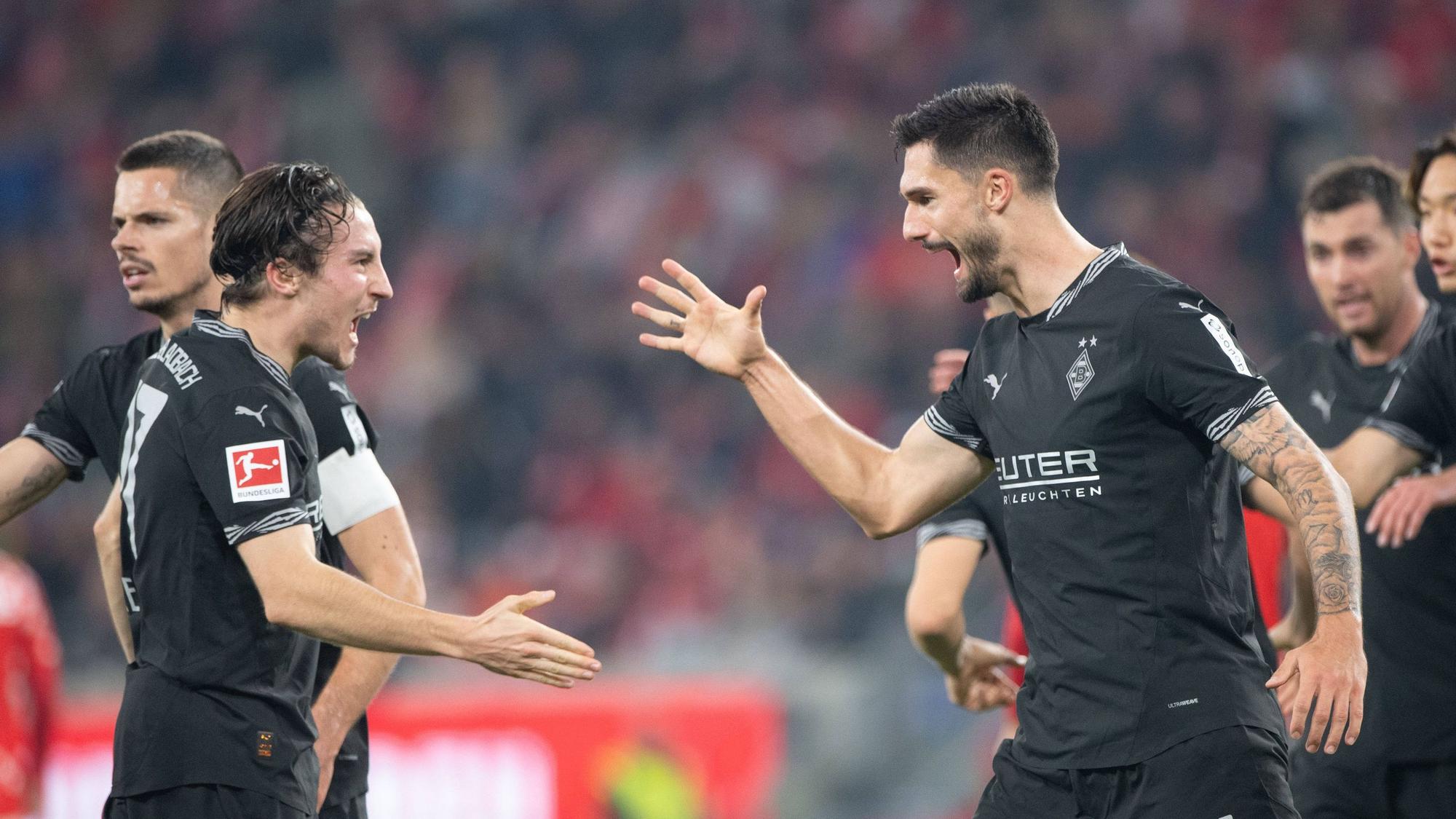 Borussia Mönchengladbachs Rocco Reitz klatscht mit Teamkollege Tim Kleindienst im Spiel beim 1. FSV Mainz 05 ab.