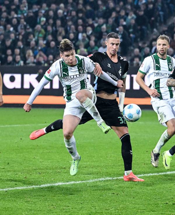 Die Gladbach-Profis Lukas Ullrich, Marvin Friedrich und Joe Scally gehen im Spiel gegen Werder Bremen zum Ball.
