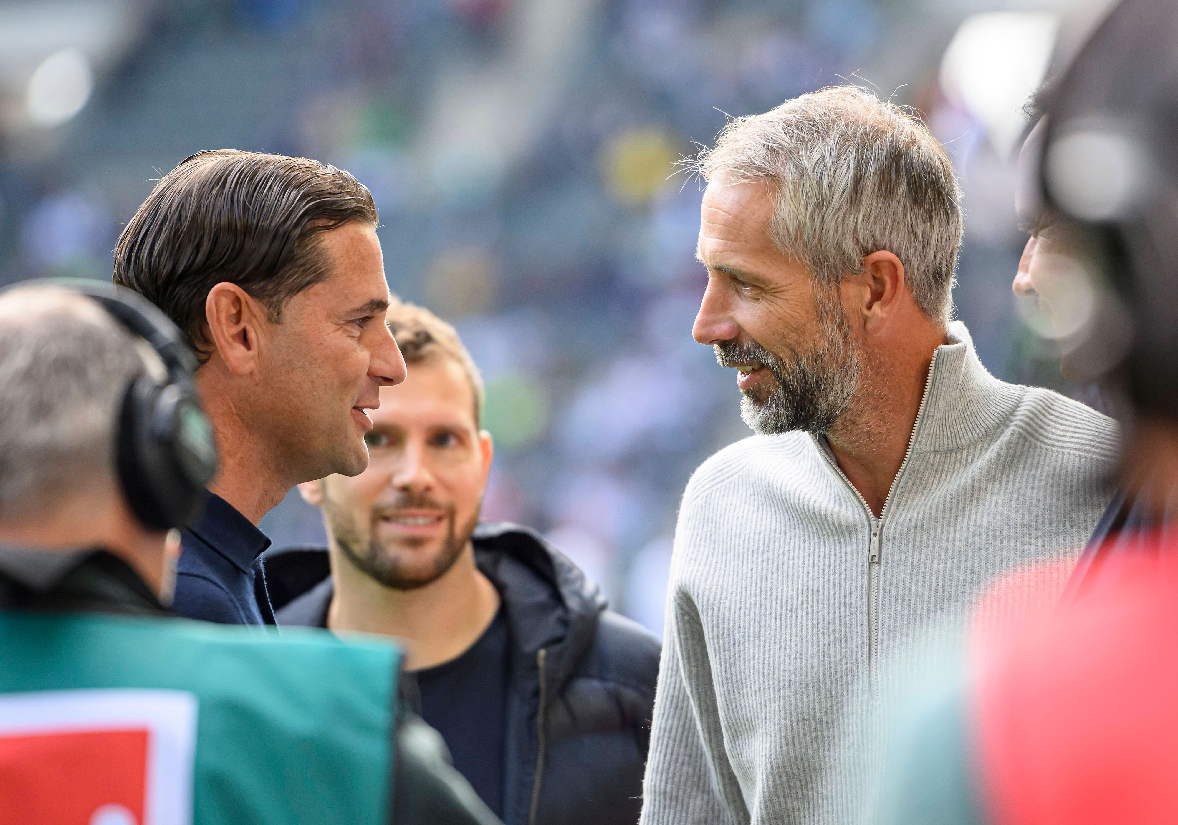 Marco Rose und Gerardo Seoane im Profil gegenüberstehend. Beide lächeln.