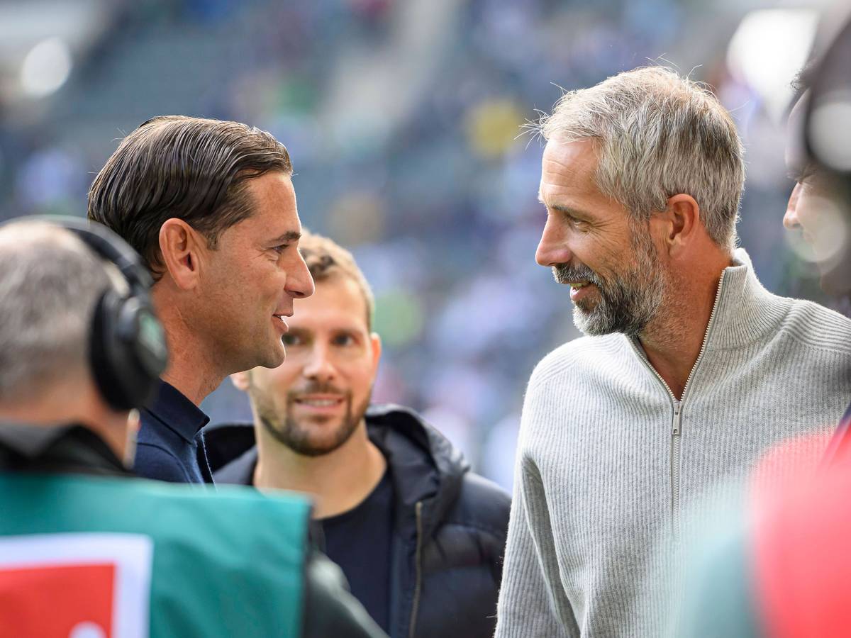 Marco Rose und Gerardo Seoane im Profil gegenüberstehend. Beide lächeln.