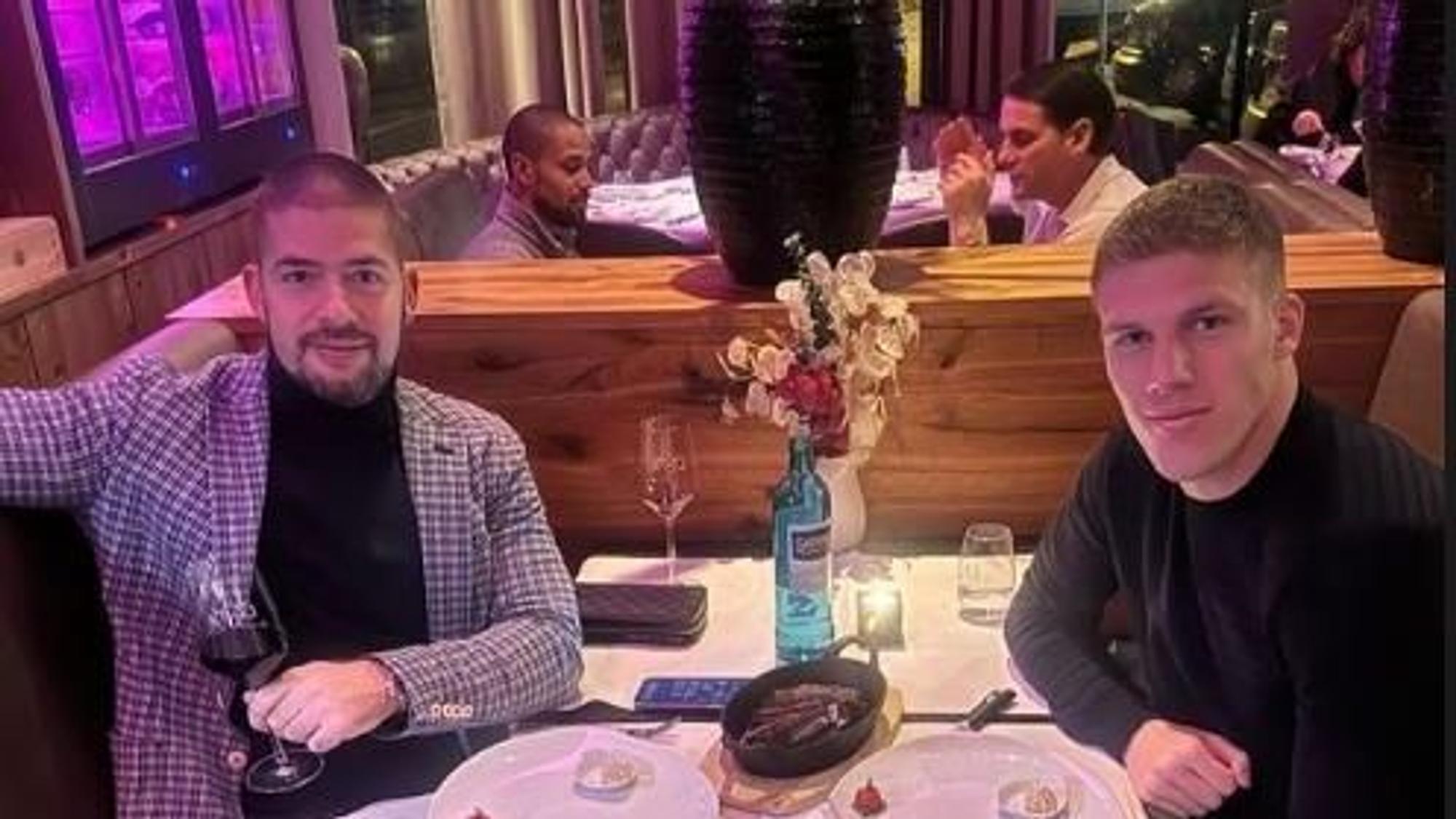 Jakov Medic und sein Cousin essen an einem Tisch. An einem Tisch im Hintergrund sitzen sich Gerardo Seoane und Sidney Sam gegenüber.