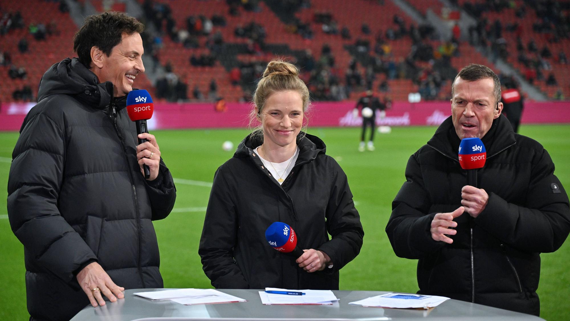Sky-Moderator Sebastian Hellmann und die Experten Tabea Kemme sowie Lothar Matthäus stehen gemeinsam in Leverkusen am Pult.