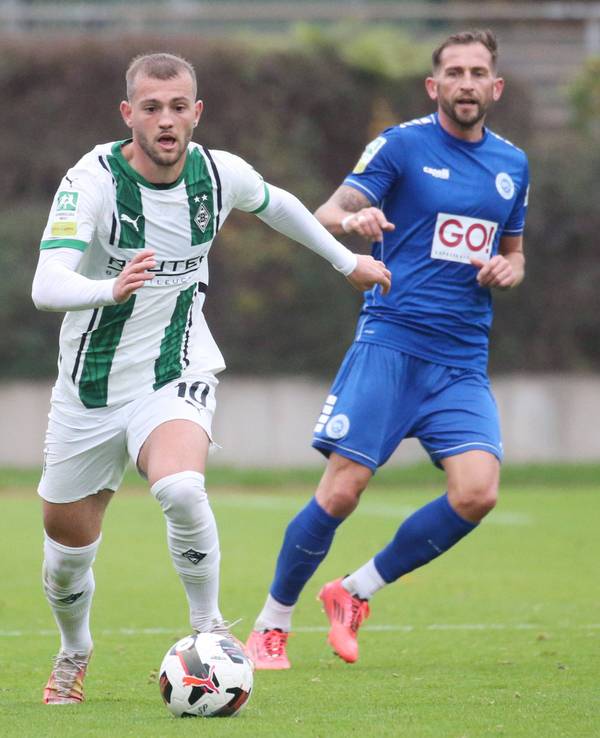 Borussia Mönchengladbachs Kushtrim Asallari führt den Ball, Lottes Marc Heider blickt hinterher.