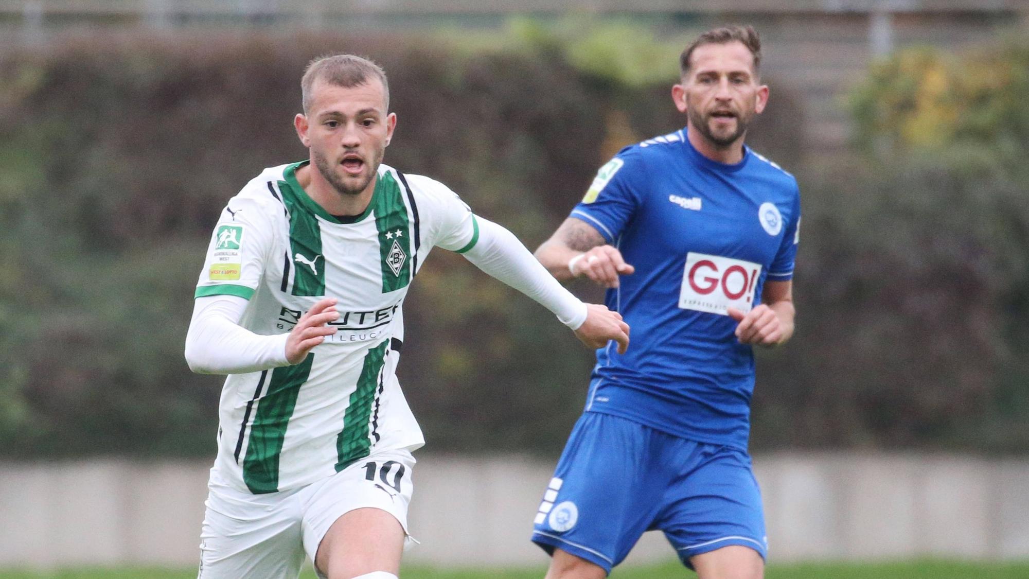 Borussia Mönchengladbachs Kushtrim Asallari führt den Ball, Lottes Marc Heider blickt hinterher.