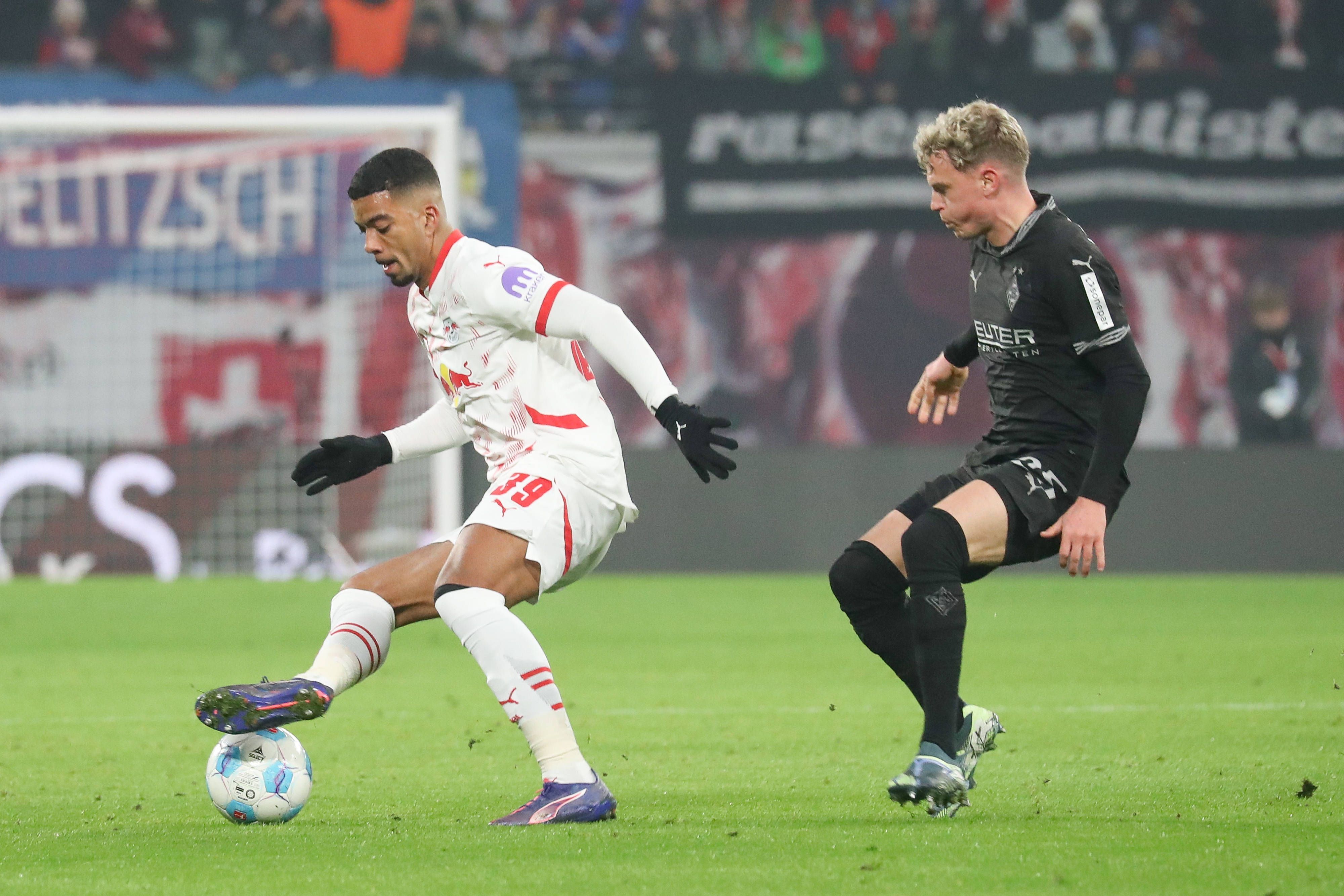 Borussia Mönchengladbachs Robin Hack kämpft mit RB Leipzigs Benjamin Henrichs um den Ball.