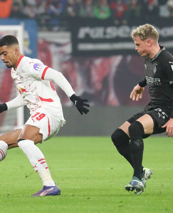 Borussia Mönchengladbachs Robin Hack kämpft mit RB Leipzigs Benjamin Henrichs um den Ball.