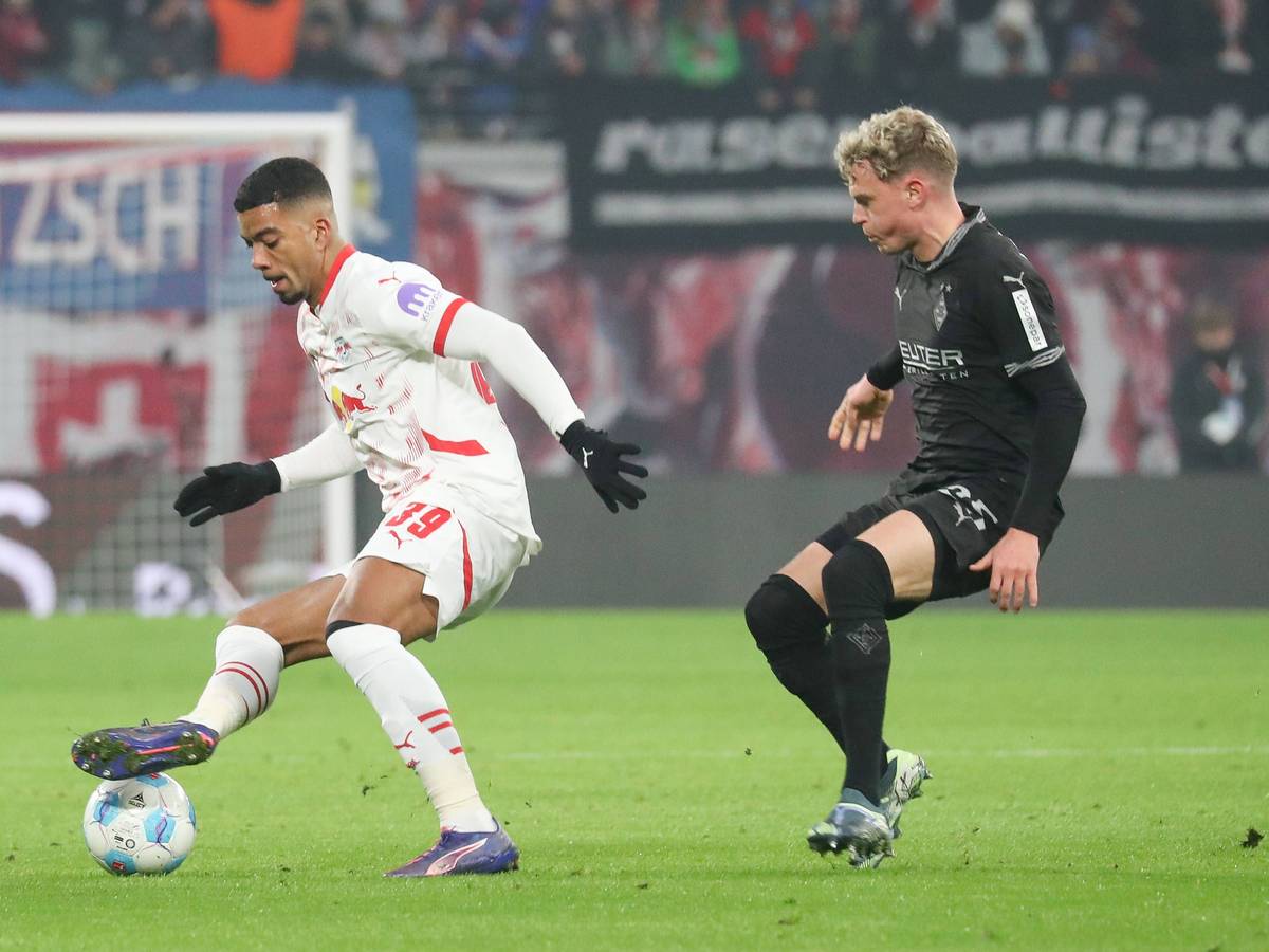Borussia Mönchengladbachs Robin Hack kämpft mit RB Leipzigs Benjamin Henrichs um den Ball.