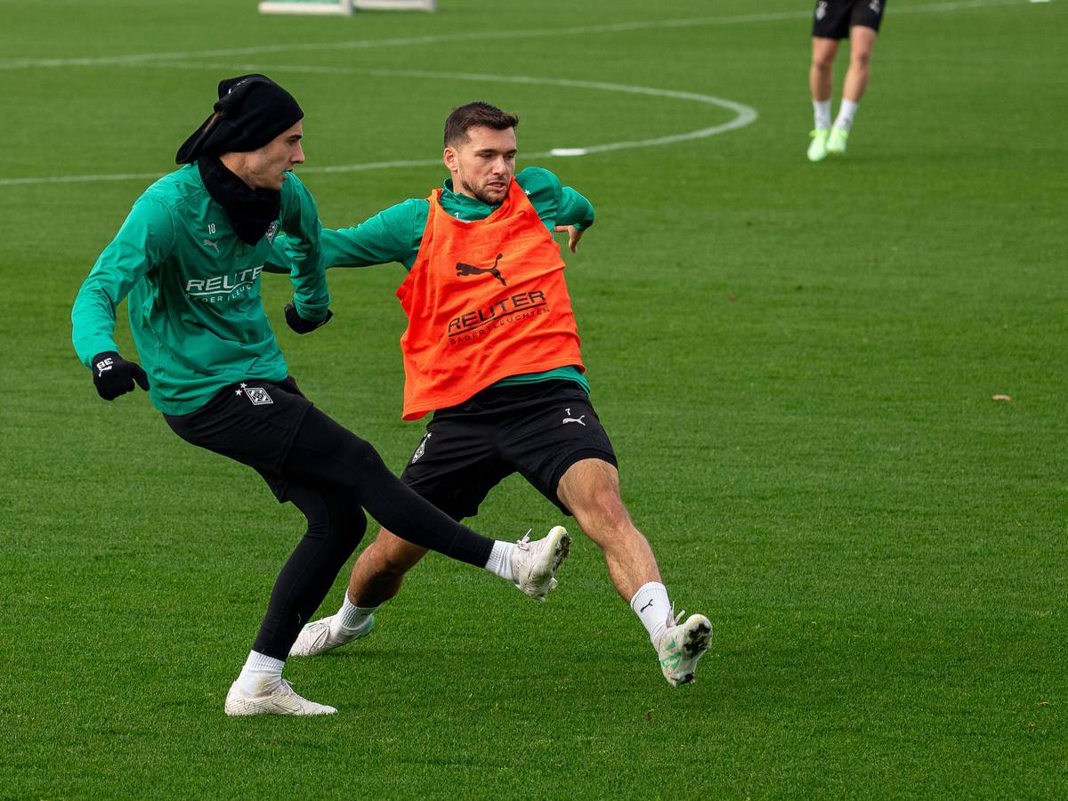 Borussia Mönchengladbachs Florian Neuhaus passt den Ball im Training, Teamkollege Kevin Stöger versucht zu blocken.