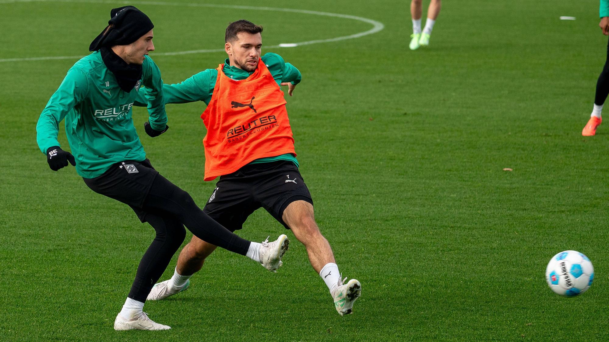 Borussia Mönchengladbachs Florian Neuhaus passt den Ball im Training, Teamkollege Kevin Stöger versucht zu blocken.