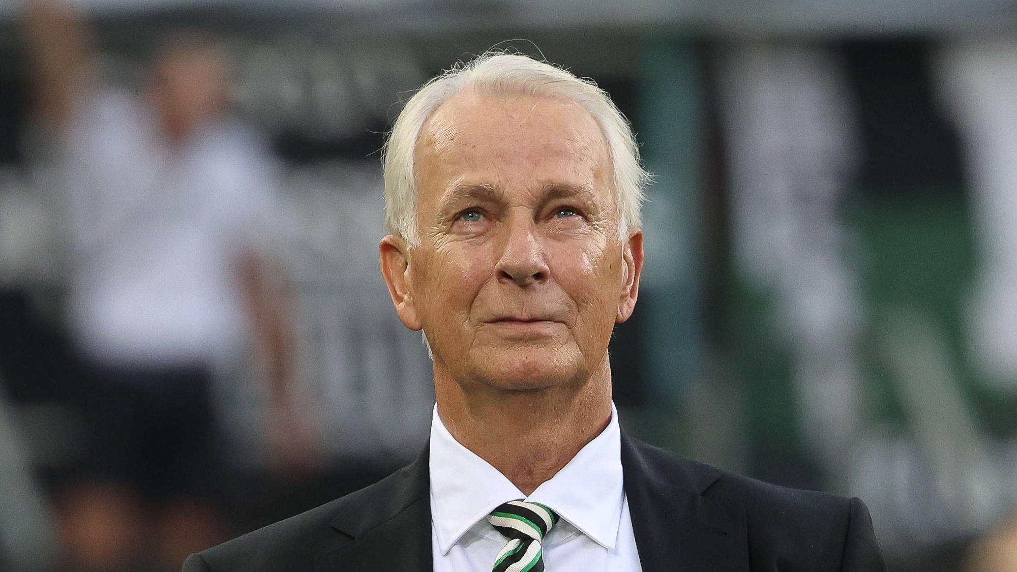 Borussia Mönchengladbachs Präsident Rainer Bonhof steht beim Bundesliga-Spiel gegen Bayer leverkusen in der Arena und blickt auf die Tribüne.