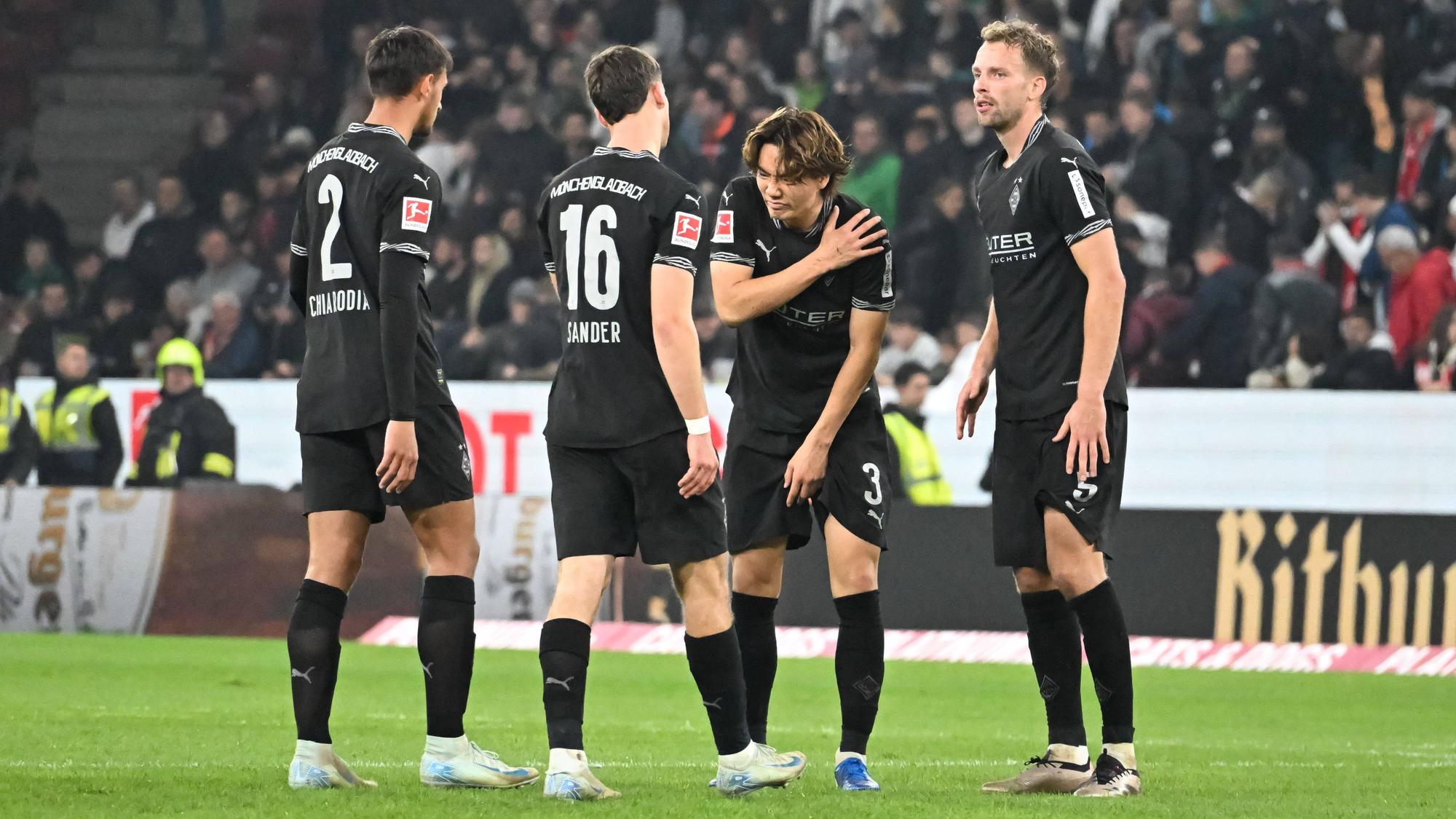 Philipp Sander steht neben drei Borussia-Innenverteidigern.