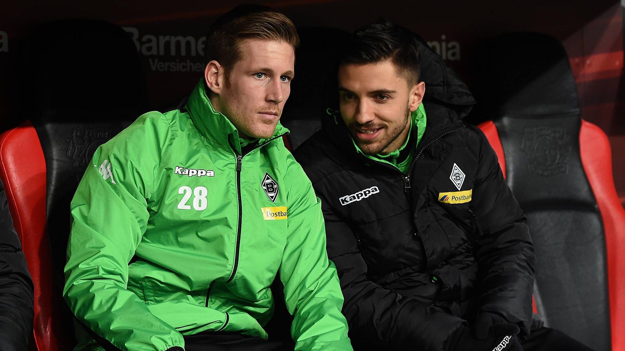 Die Gladbach-Profis André Hahn und Julian Korb unterhalten sich beim Bundesliga-Spiel in Leverkusen auf der Bank.