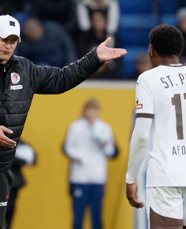 St. Paulis Trainer Alexander Blessin gibt seinem Stürmer Oladapo Afolayan im Spiel bei der TSG Hoffenheim an der Seitenlinie Anweisungen.