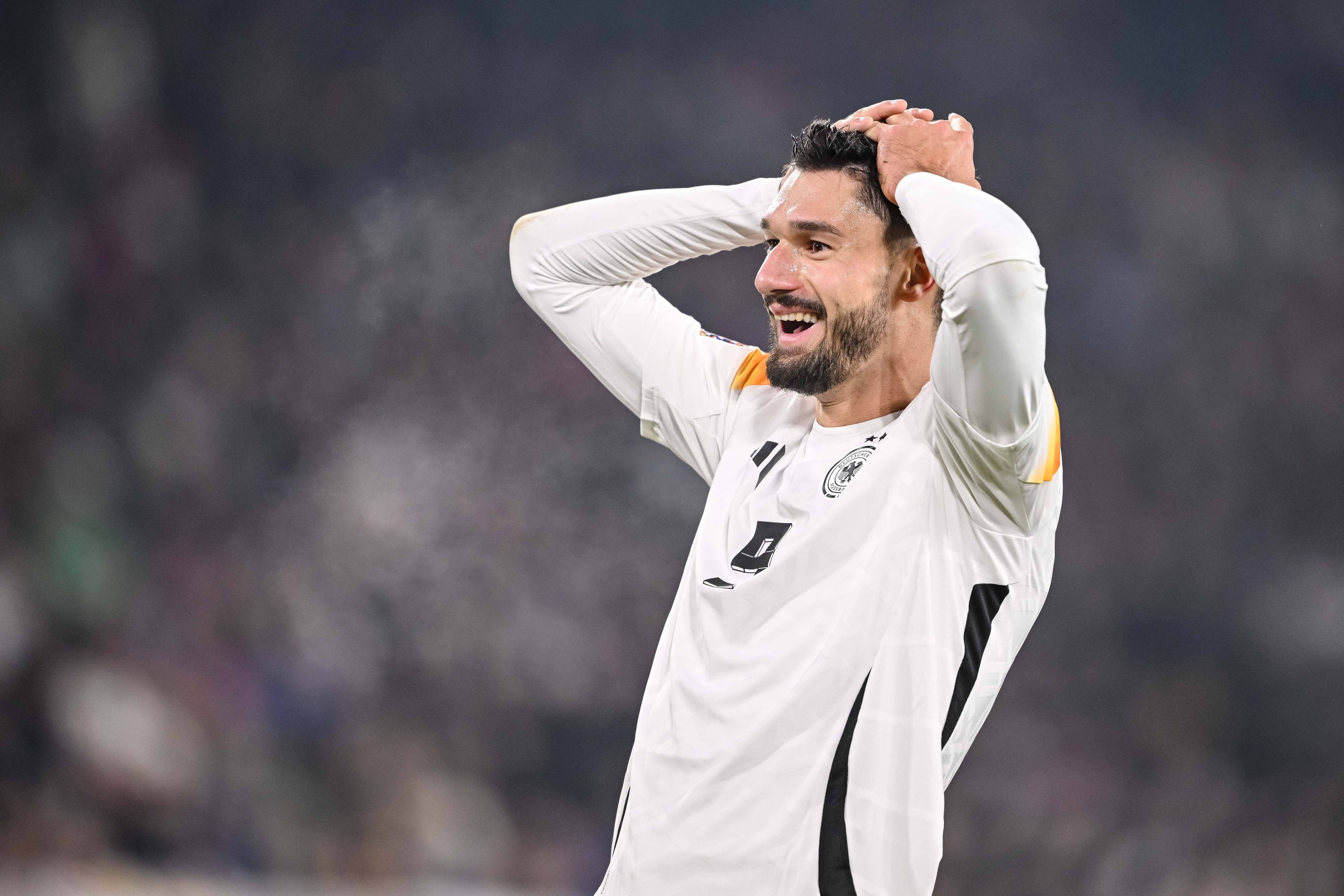 Deutschlands Nationalspieler Tim Kleindienst schlägt im Spiel gegen Bosnien-Herzegowina lachend die Hände über dem Kopf zusammen.