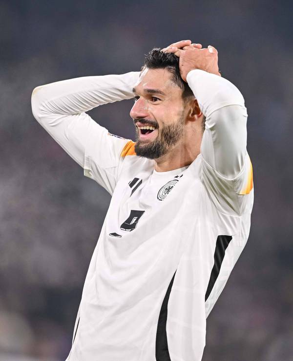 Deutschlands Nationalspieler Tim Kleindienst schlägt im Spiel gegen Bosnien-Herzegowina lachend die Hände über dem Kopf zusammen.