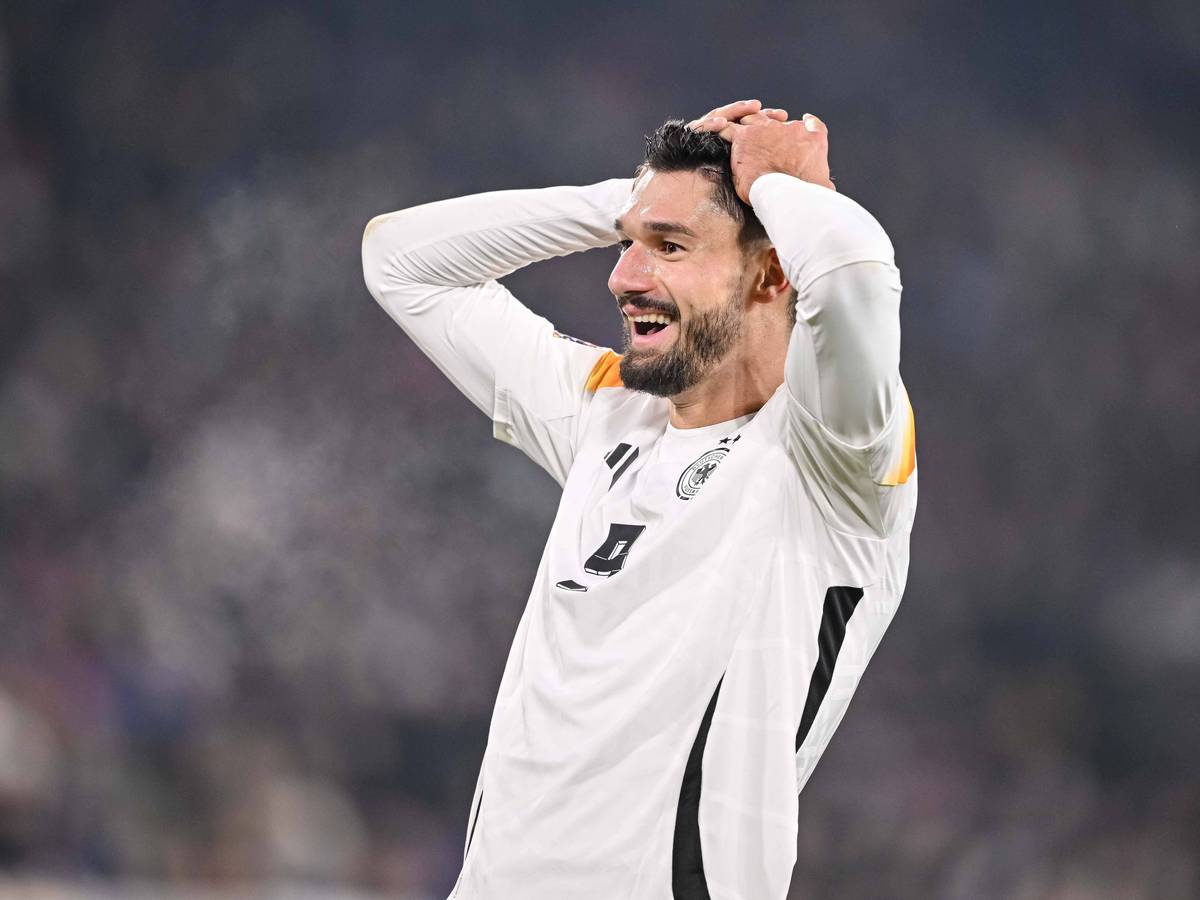 Deutschlands Nationalspieler Tim Kleindienst schlägt im Spiel gegen Bosnien-Herzegowina lachend die Hände über dem Kopf zusammen.