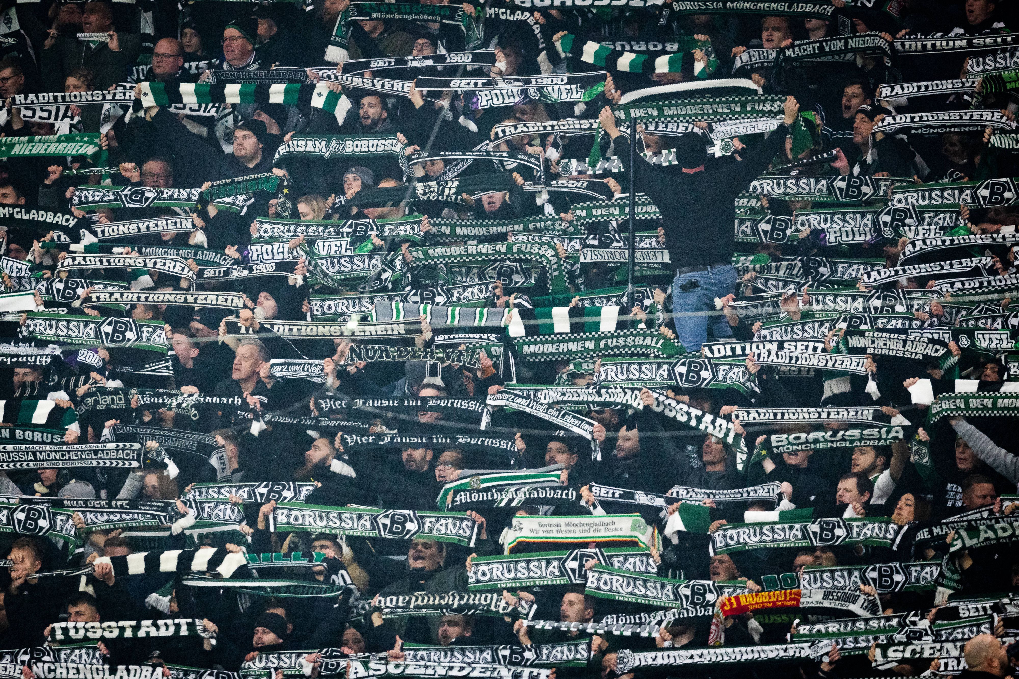 Fans von Borussia Mönchengladbach halten beim Auswärtsspiel gegen RB Leipzig ihre Schals in die Höhe.