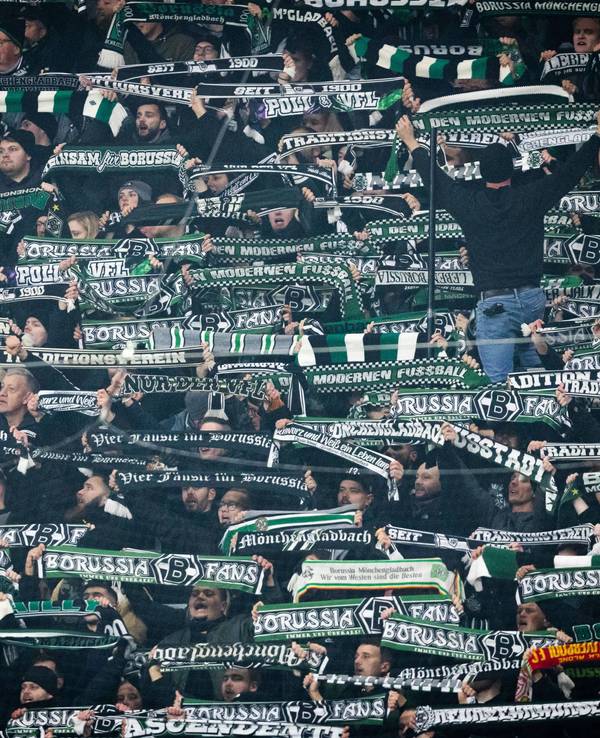 Fans von Borussia Mönchengladbach halten beim Auswärtsspiel gegen RB Leipzig ihre Schals in die Höhe.