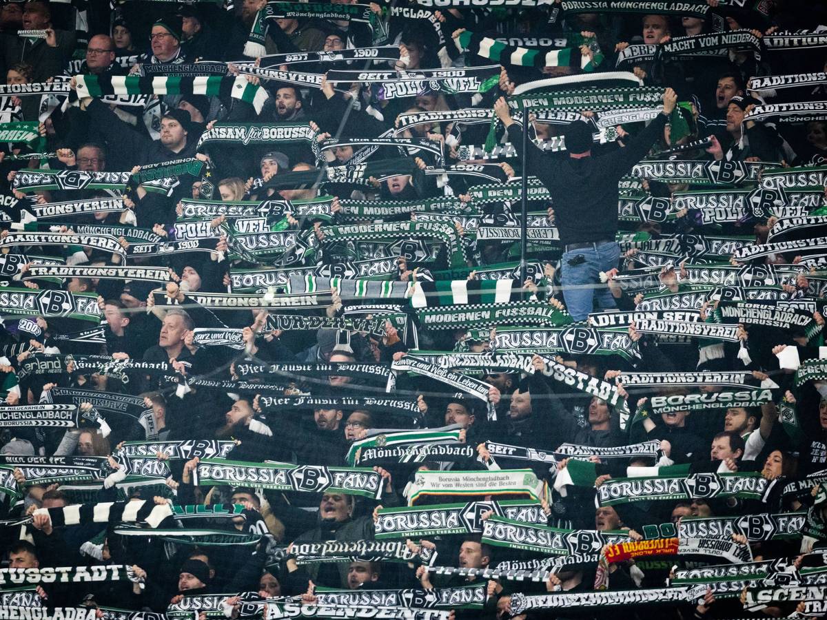 Fans von Borussia Mönchengladbach halten beim Auswärtsspiel gegen RB Leipzig ihre Schals in die Höhe.