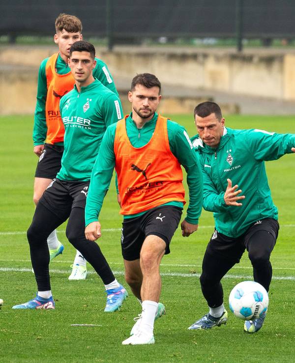 Borussia Mönchengladbachs Kevin Stöger und Teamkollege Stefan Lainer kämpfen im Training um den Ball. Im Hintergrund beobachten Grant-Leon Ranos und Lukas Ullrich die Szene.