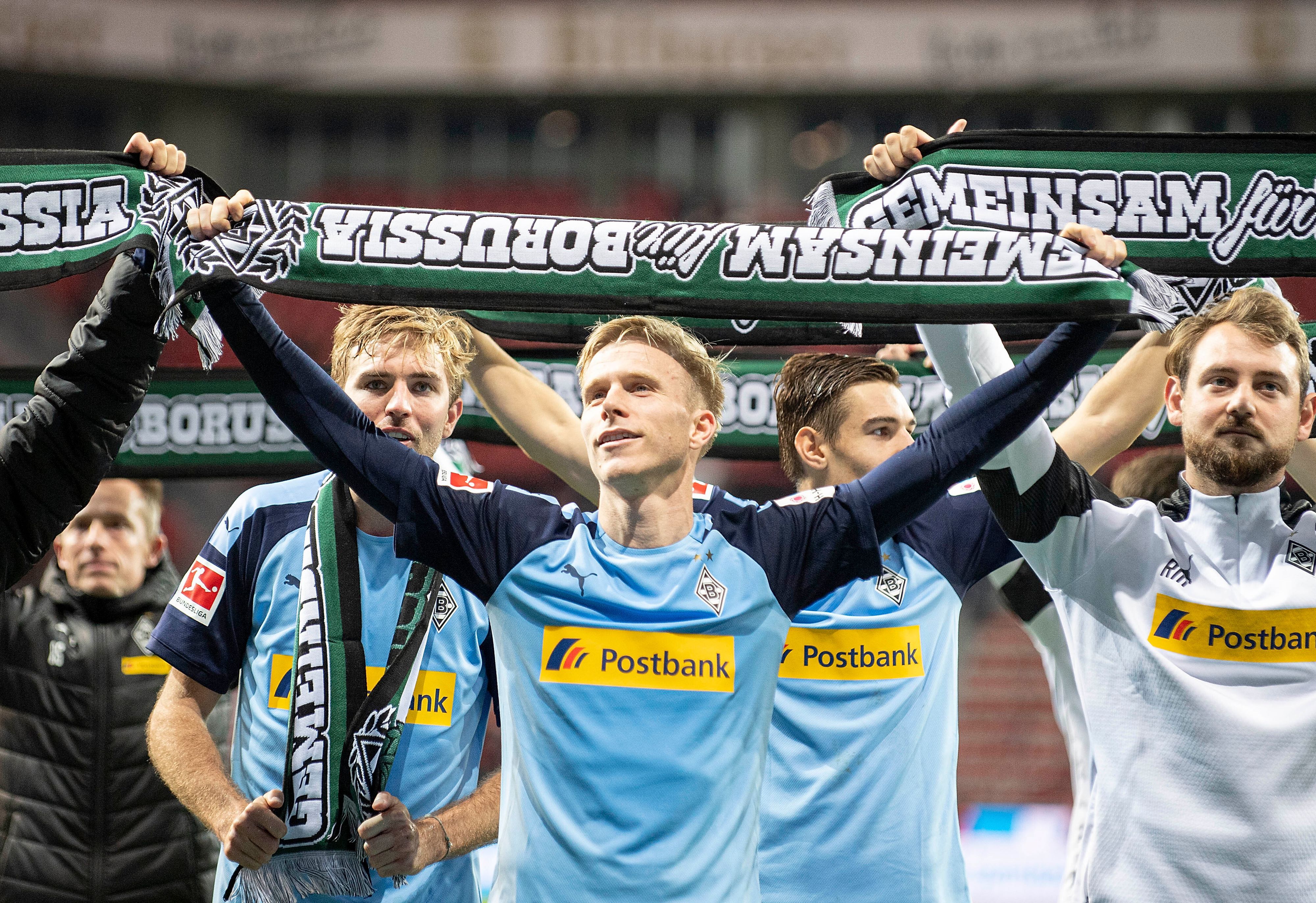 Oscar Wendt hält einen Borussia-Schal hoch.