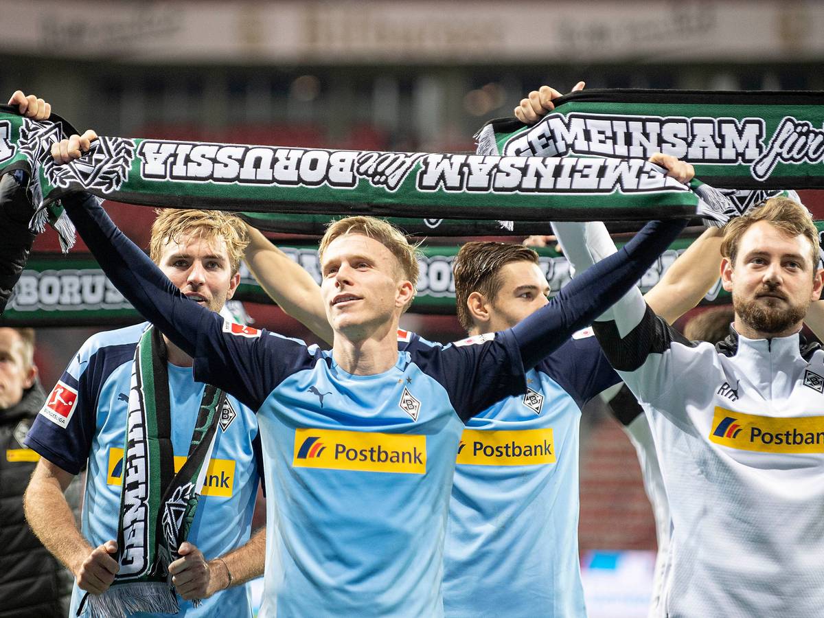Oscar Wendt hält einen Borussia-Schal hoch.