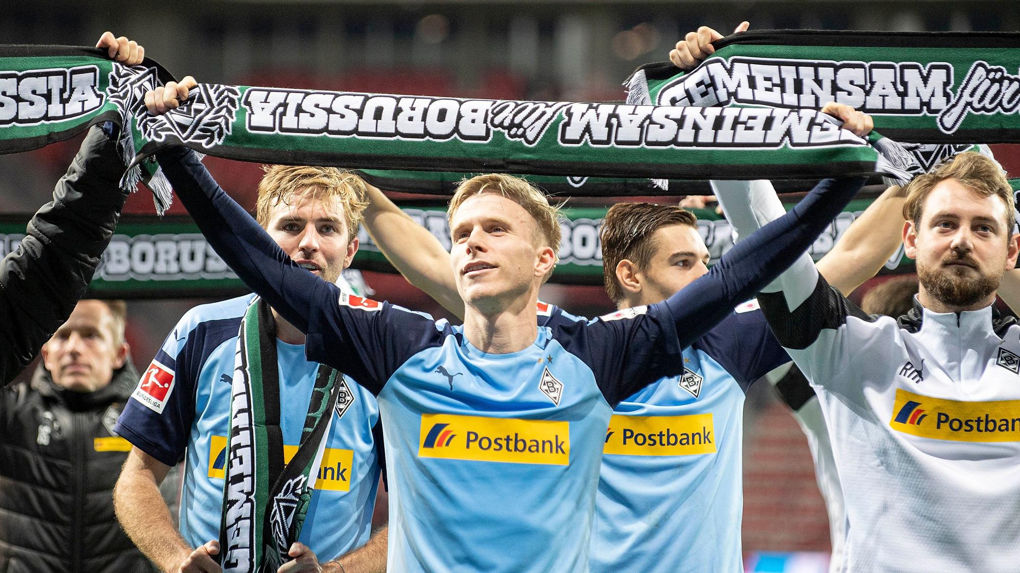 Oscar Wendt hält einen Borussia-Schal hoch.