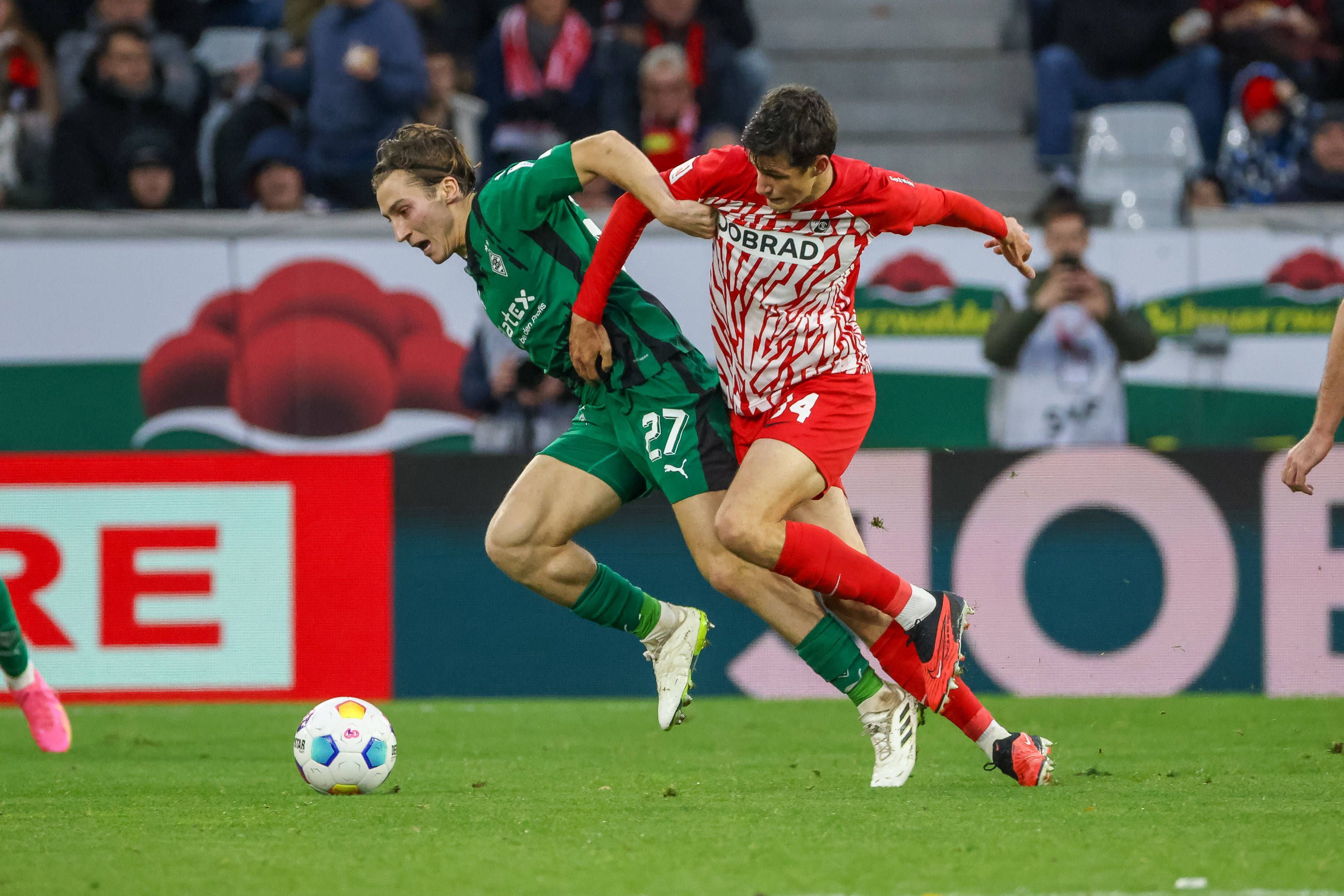 Borussia Mönchengladbachs Rocco Reitz kämpft mit Freiburgs Merlin Röhl um den Ball.