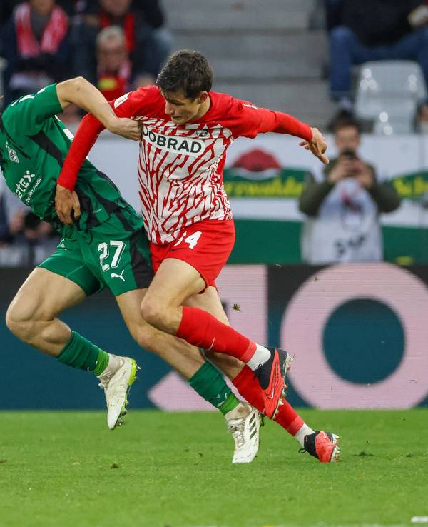 Borussia Mönchengladbachs Rocco Reitz kämpft mit Freiburgs Merlin Röhl um den Ball.