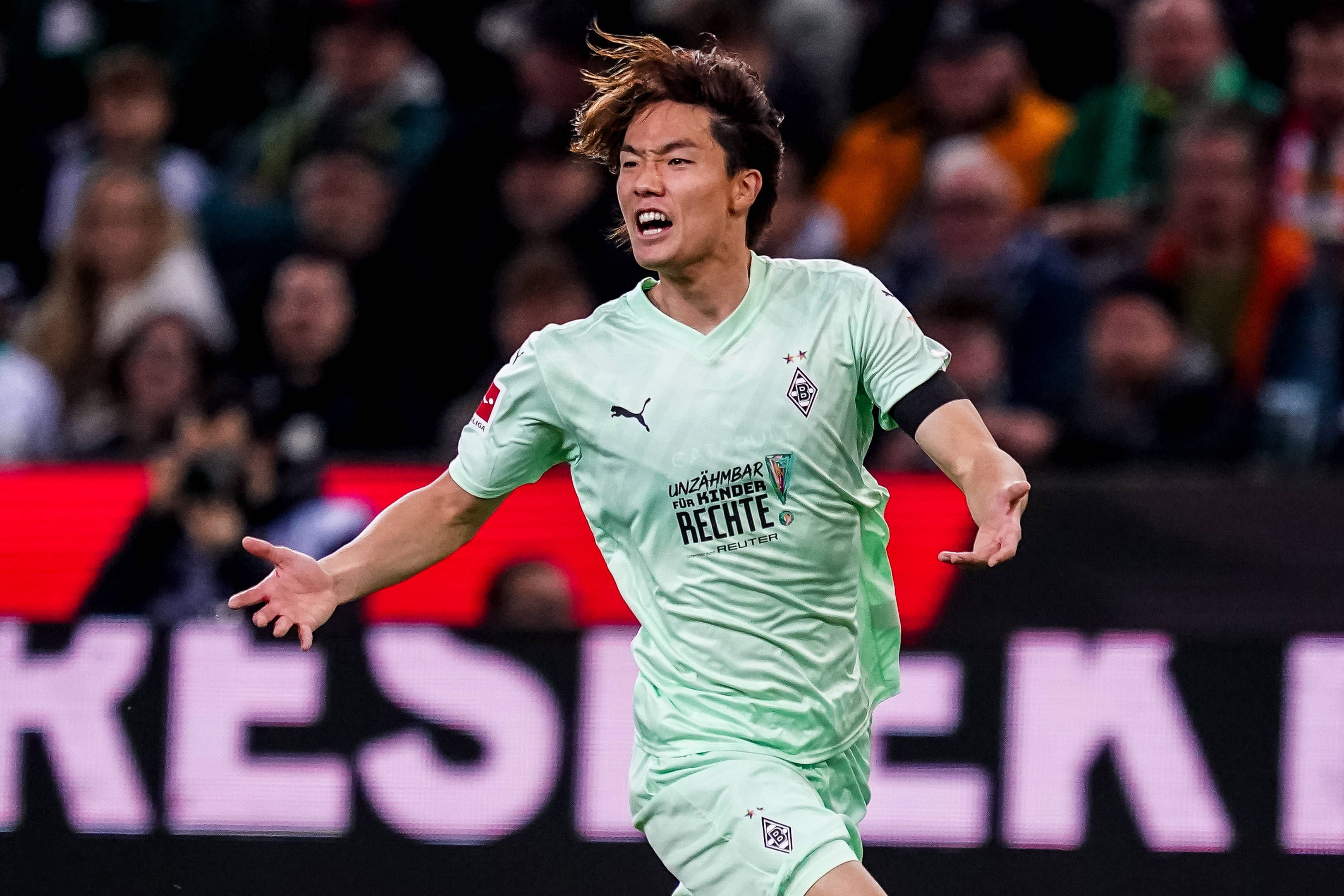 Ko Itakura schreit lauthals auf dem Platz und breitet seine Arme dabei aus.