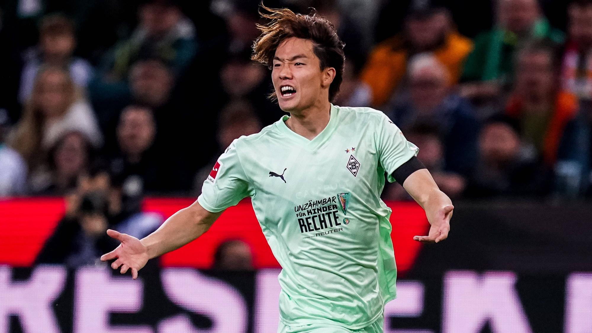 Ko Itakura schreit lauthals auf dem Platz und breitet seine Arme dabei aus.