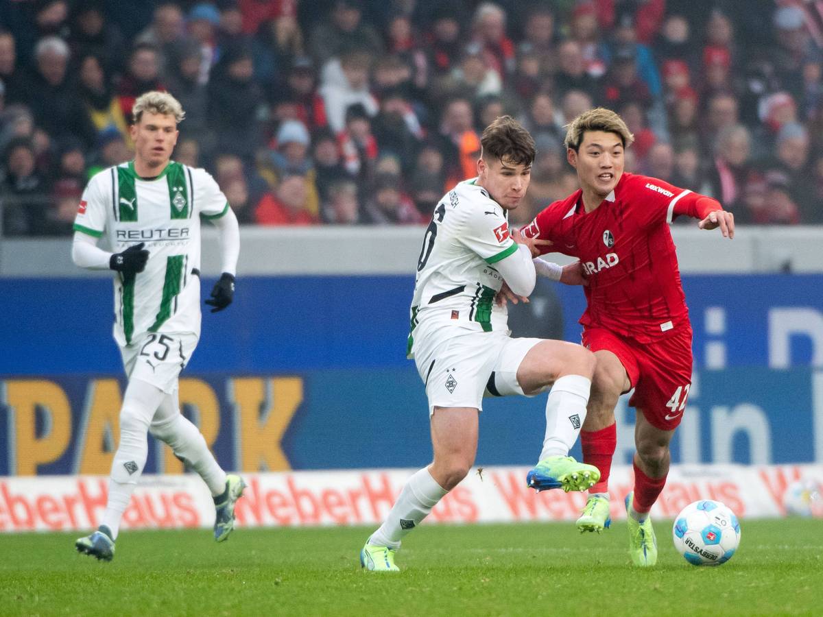 Borussia Mönchengladbachs Lukas Ullrich kämpft mit Freiburgs Ritsu Doan um den Ball.