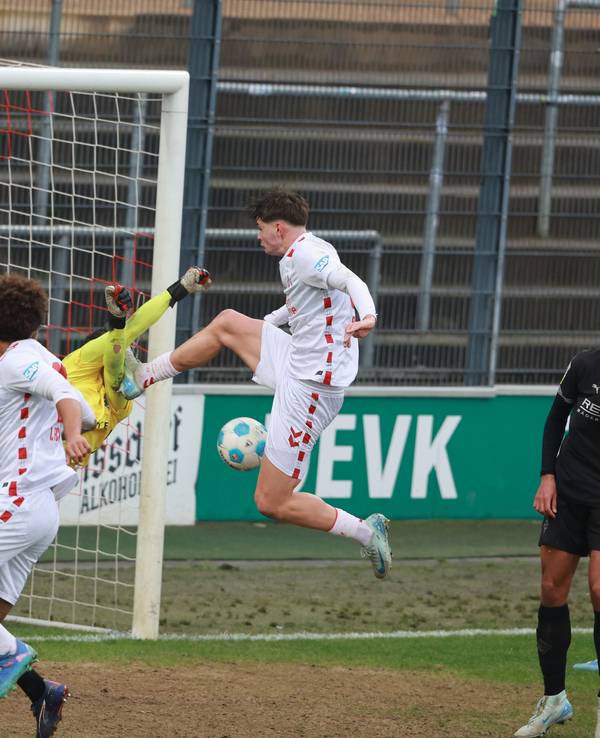 Kölns Stürmer Jaka Cuber Potocnik trifft Borussia Mönchengladbachs Torwart Maximilian Neutgens mit dem Fuß am Oberkörper.
