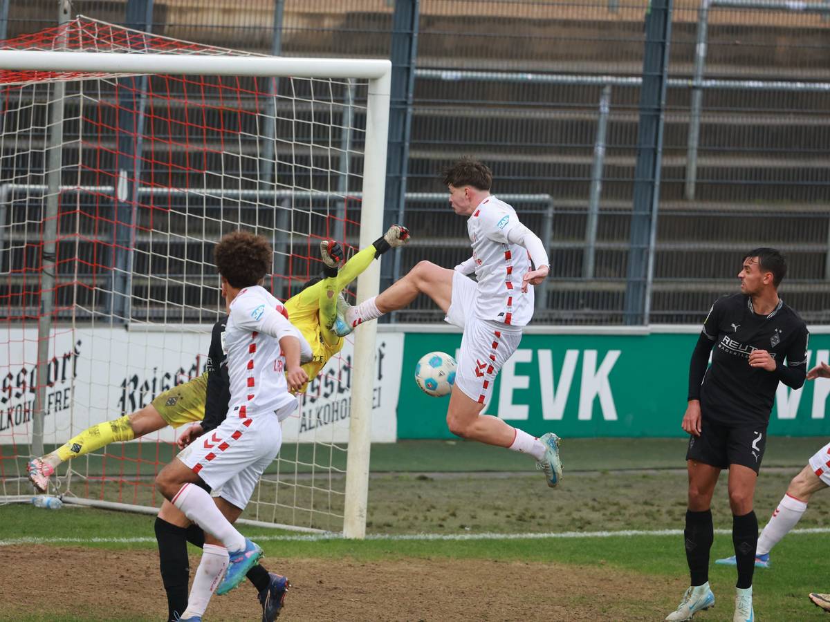 Kölns Stürmer Jaka Cuber Potocnik trifft Borussia Mönchengladbachs Torwart Maximilian Neutgens mit dem Fuß am Oberkörper.