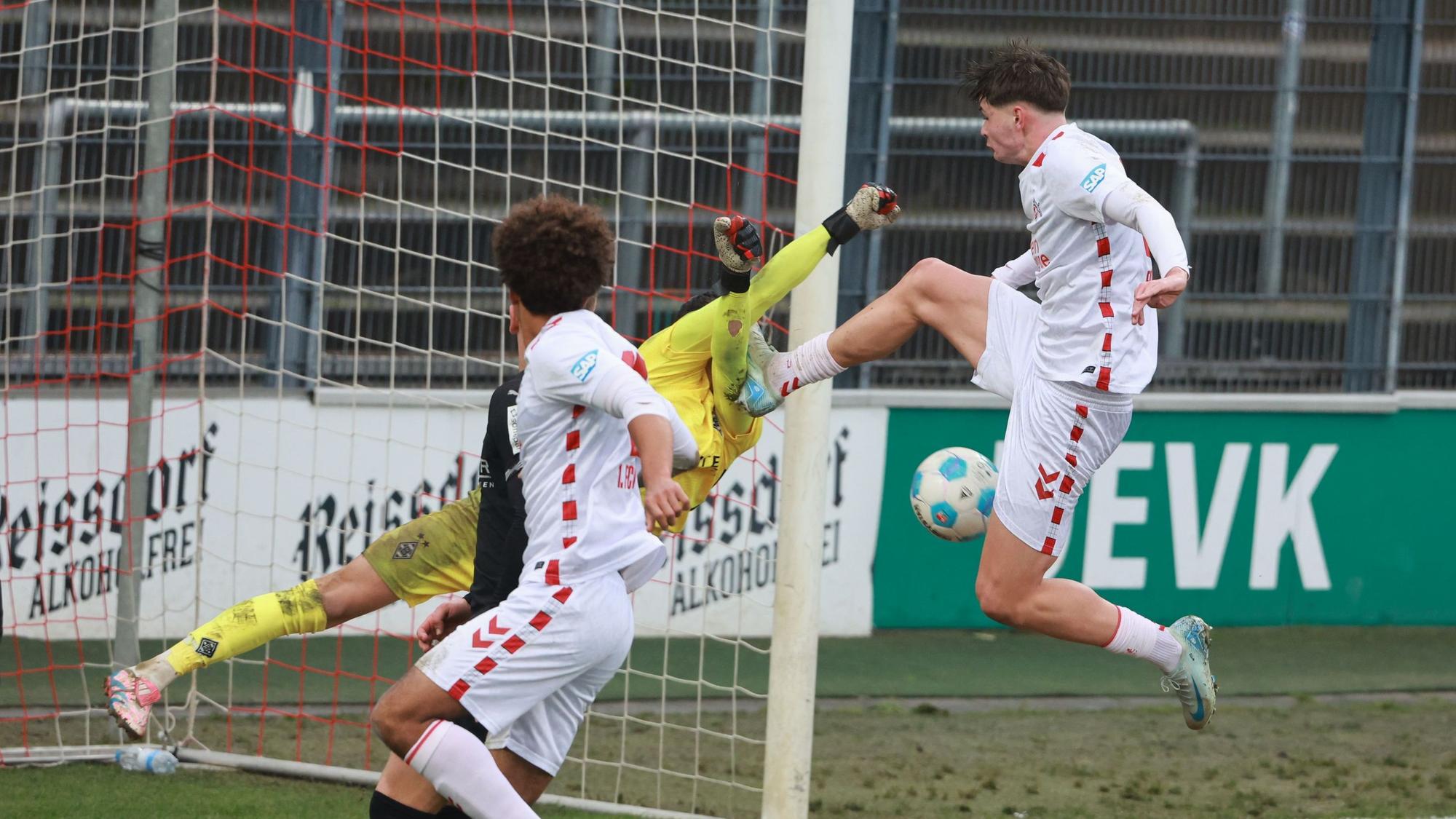 Kölns Stürmer Jaka Cuber Potocnik trifft Borussia Mönchengladbachs Torwart Maximilian Neutgens mit dem Fuß am Oberkörper.