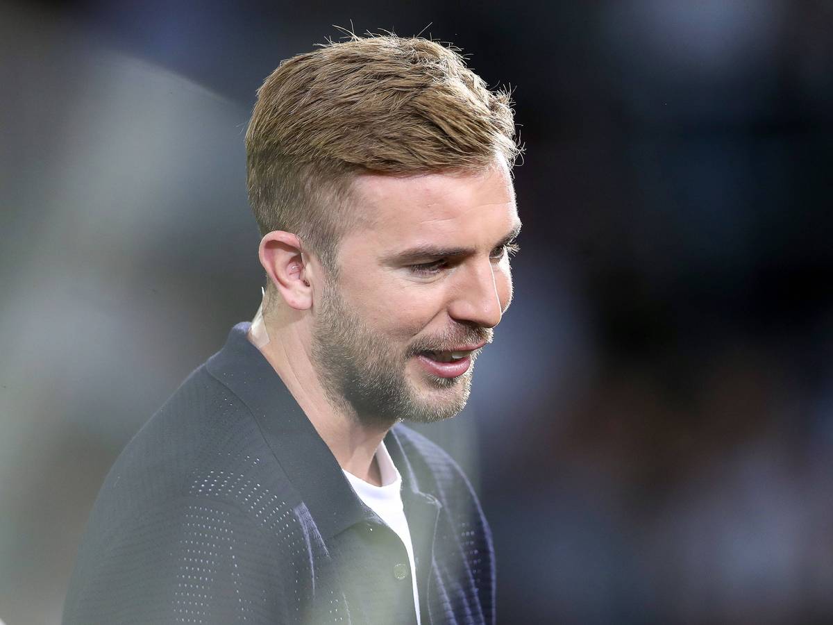 TV-Experte Christoph Kramer steht beim Nations-League-Spiel Deutschland gegen Ungarn im Stadion und lächelt.