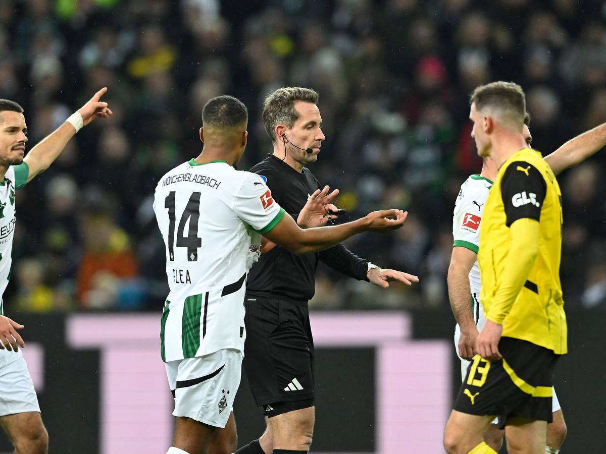 Spieler von Borussia Mönchengladbach diskutieren mit dem Schiedsrichter.