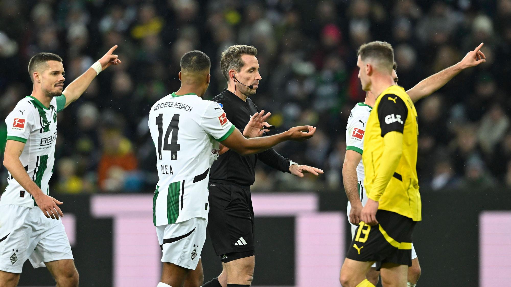 Spieler von Borussia Mönchengladbach diskutieren mit dem Schiedsrichter.