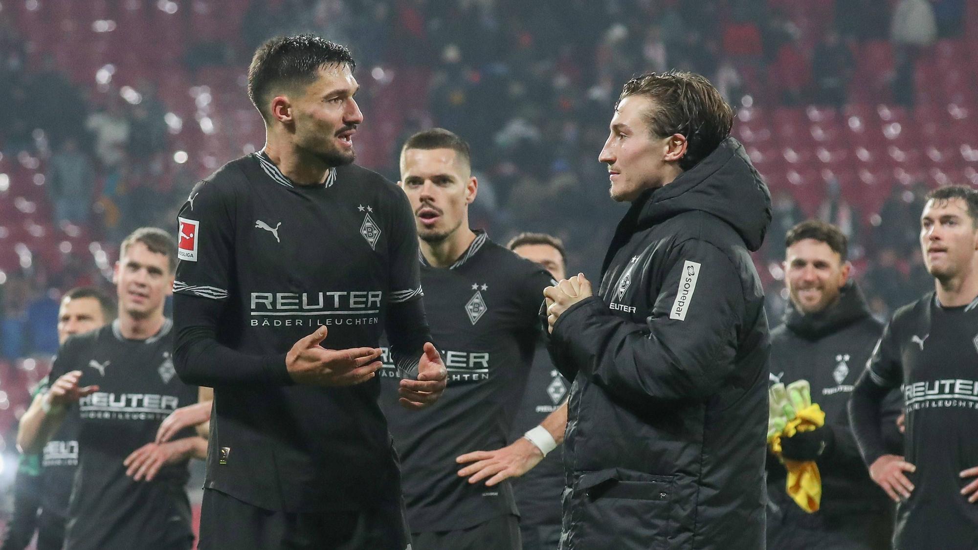 Die Gladbach-Profis Tim Kleindienst und Rocco Reitz unterhalten sich nach dem Spiel bei RB Leipzig auf dem Platz.