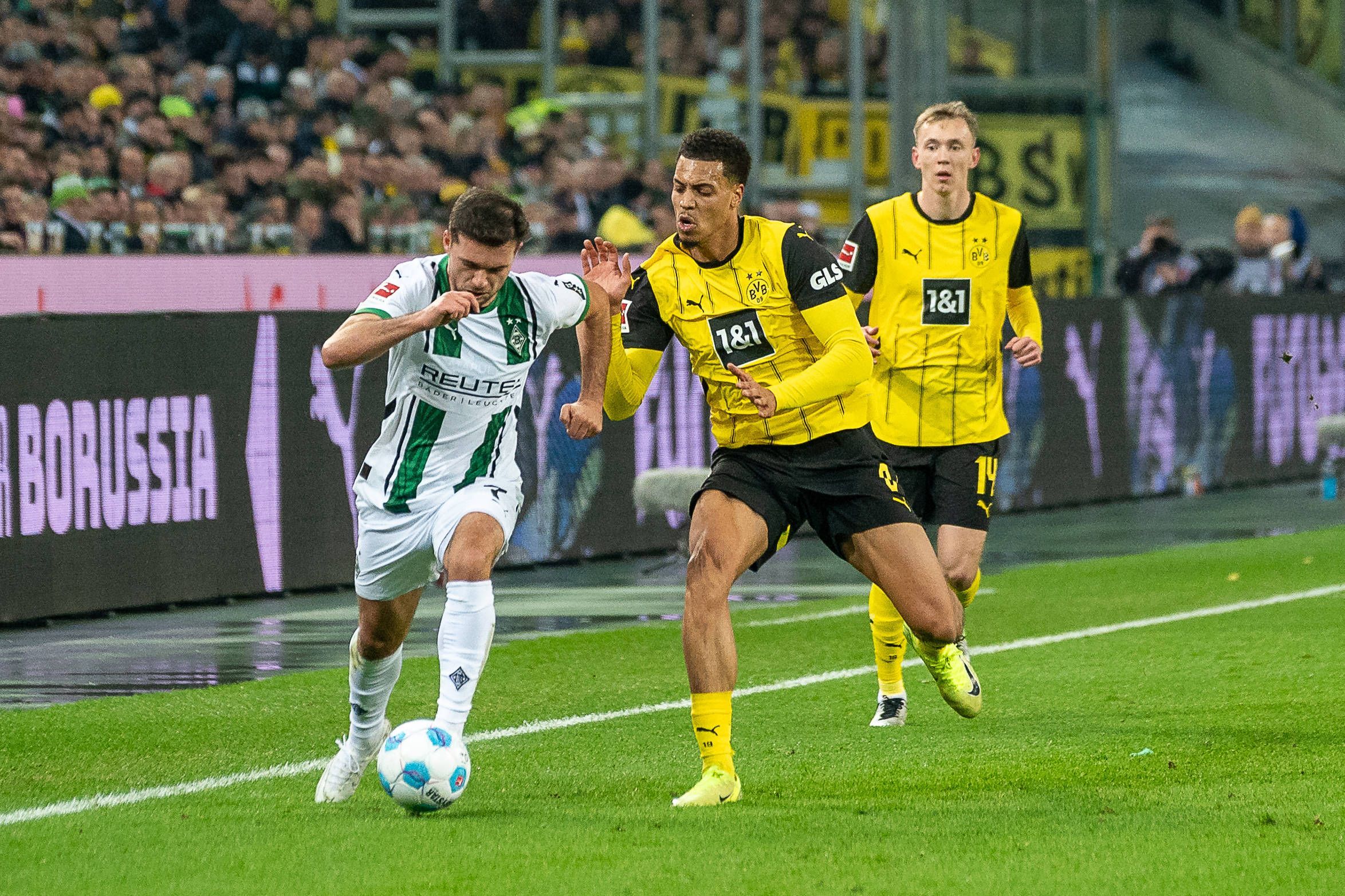 Borussia Mönchengladbachs Kevin Stöger kämpft mit Borussia Dortmunds Felix Nmecha um den Ball.