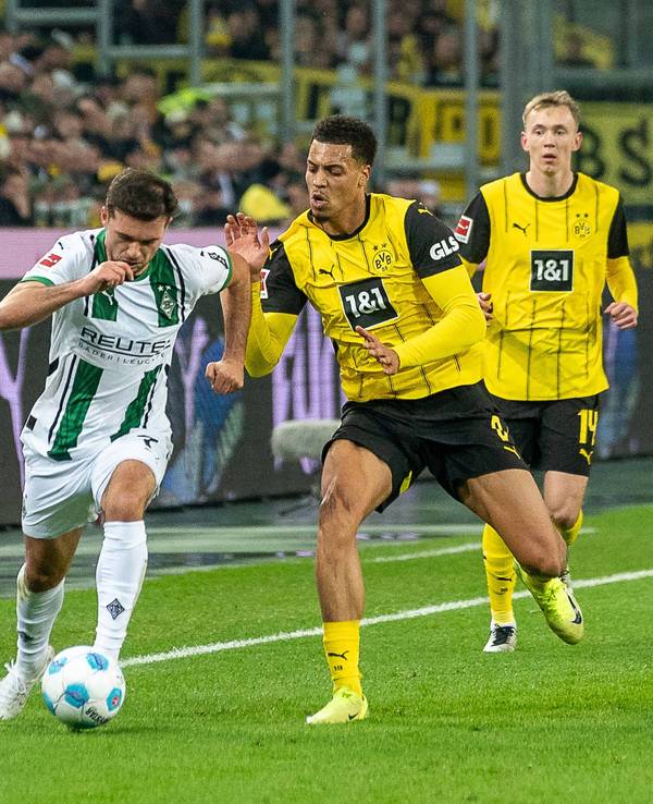 Borussia Mönchengladbachs Kevin Stöger kämpft mit Borussia Dortmunds Felix Nmecha um den Ball.