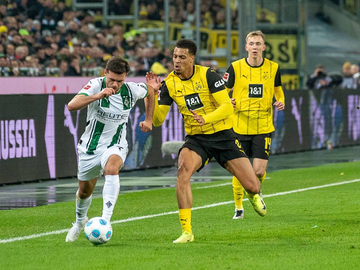 Borussia Mönchengladbachs Kevin Stöger kämpft mit Borussia Dortmunds Felix Nmecha um den Ball.