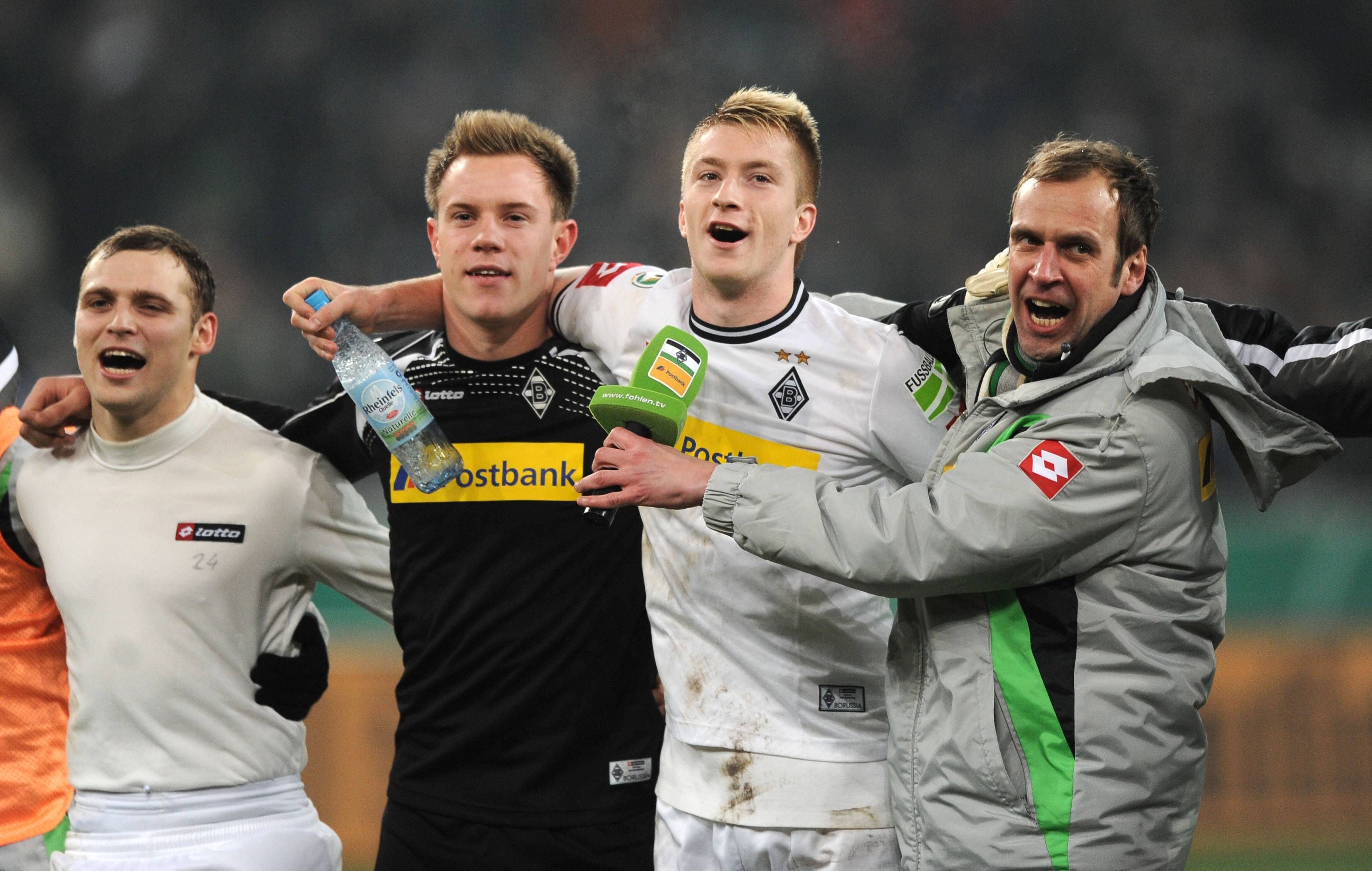 Tony Jantschke, Marc-André ter Stegen, Marco Reus und Stadionsprecher Thorsten Knippertz jubeln vor der Kurve Arm in Arm.