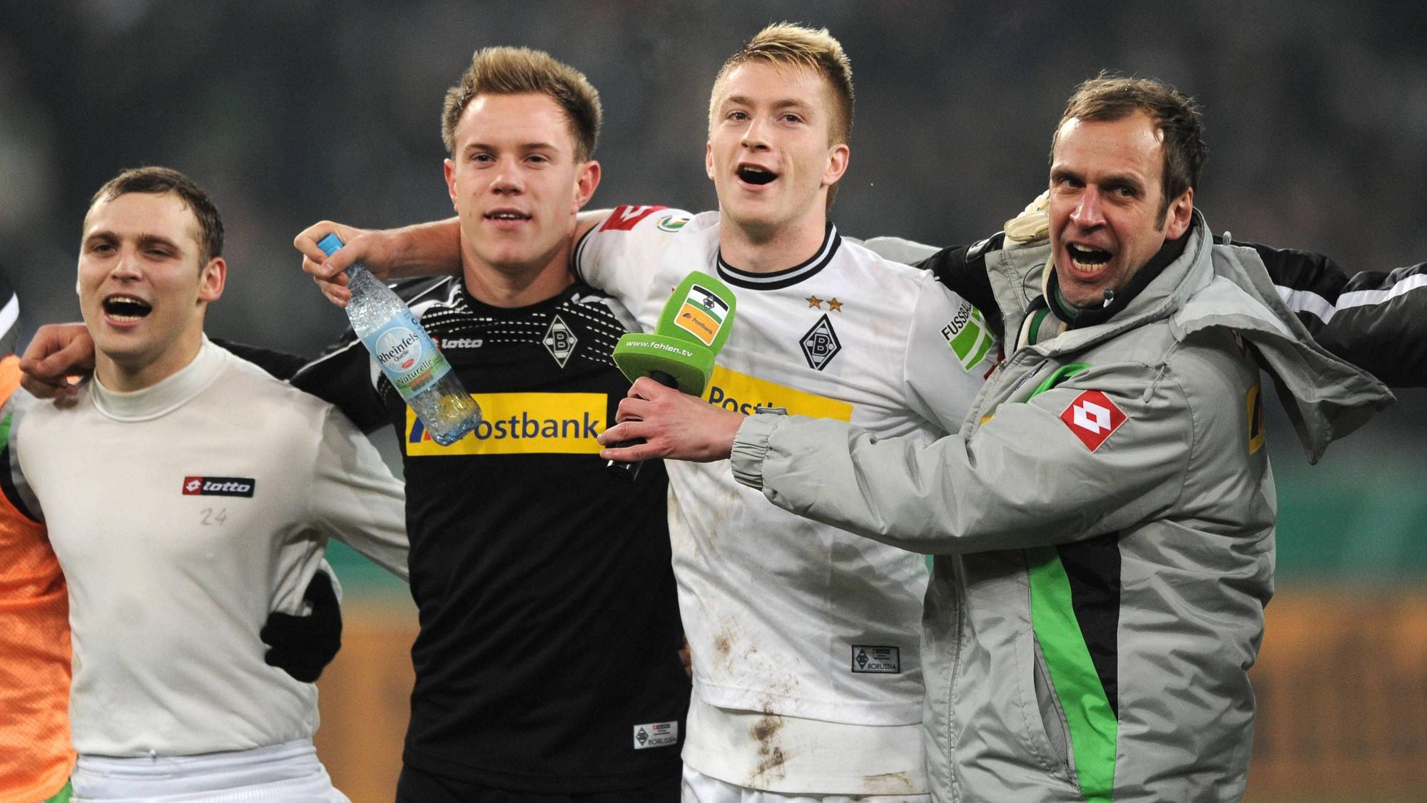 Tony Jantschke, Marc-André ter Stegen, Marco Reus und Stadionsprecher Thorsten Knippertz jubeln vor der Kurve Arm in Arm.